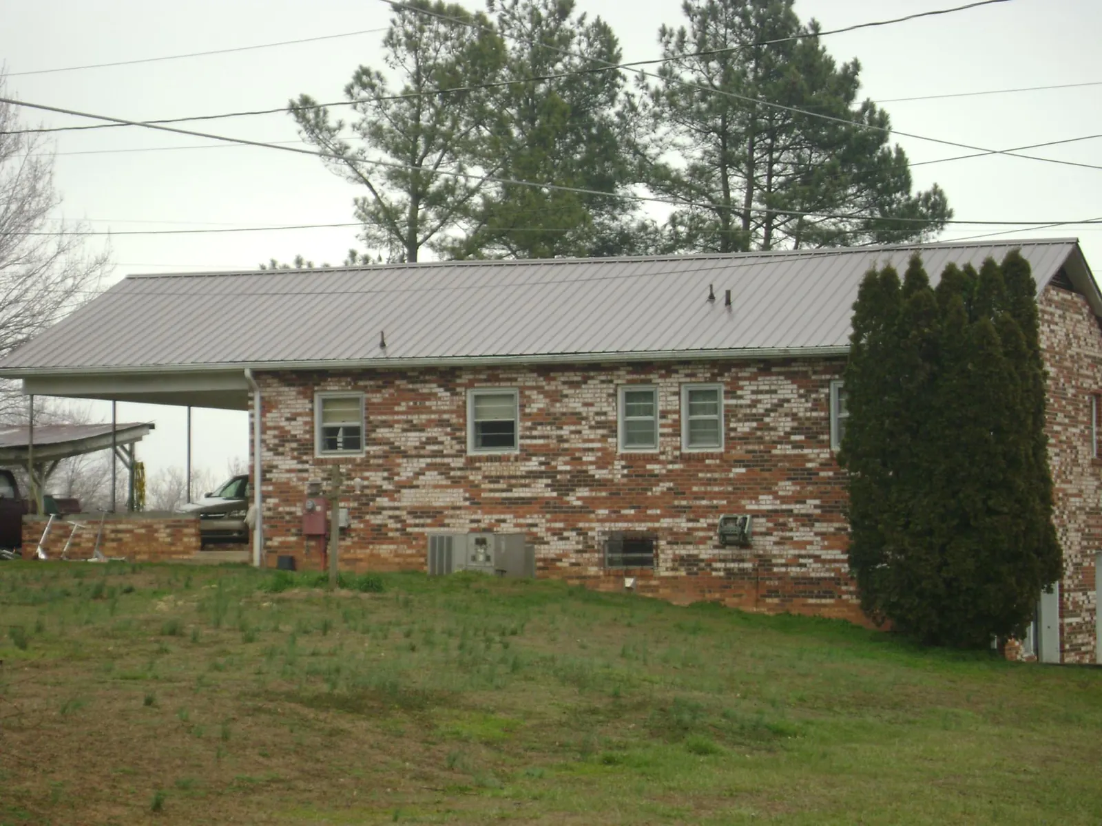 Gray metal roof on a brick split level home with a carport in Sibley